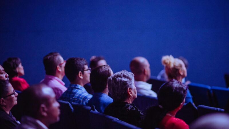 People in an audience listening to presentation