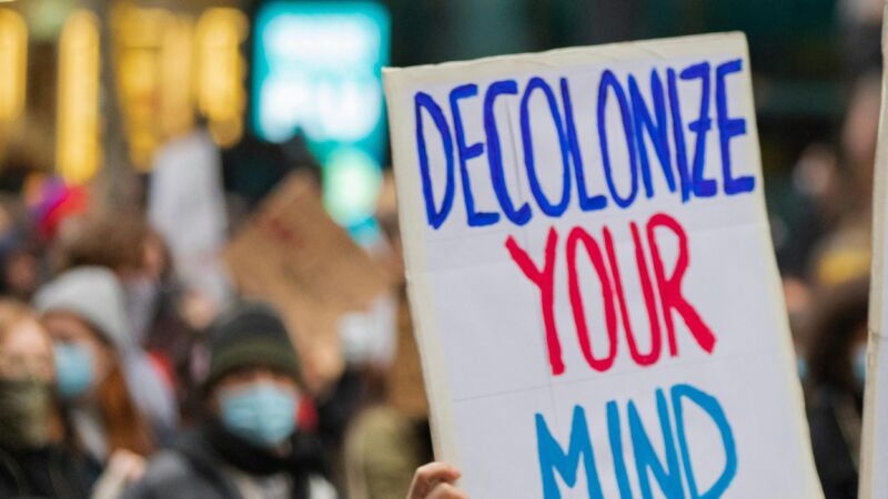 Protest poster that says "Decolonize your mind," photo by Mitchell Luo, Pexels